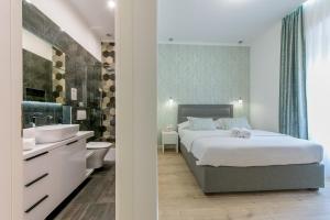 a bedroom with a bed and a bathroom with a sink at Arcus Apartment & Arcus Room in Split