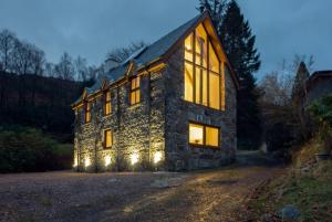 uma casa de pedra com luzes de Natal em The Armoury em Glenfinnan