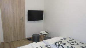 ein Schlafzimmer mit einem Bett und einem TV an der Wand in der Unterkunft HU in Prag