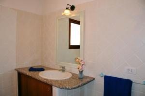 a bathroom with a sink and a mirror at Le Tre Querce in San Teodoro +21 photos