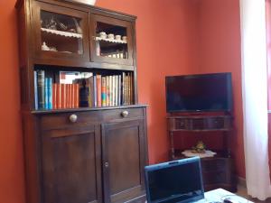 a large wooden entertainment center with a tv and a book shelf at Casa Llorente in Meré