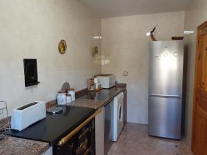 a kitchen with a refrigerator and a counter top at Casa Llorente in Meré