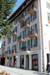 ein weißes Gebäude mit Balkon auf einer Straße in der Unterkunft Appartement Le Lutetia in Chamonix-Mont-Blanc