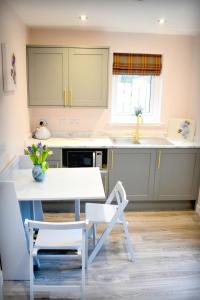 a kitchen with a white table and chairs in a room at The Auld Reekie in Barbaraville