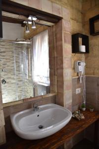 Bifarville Bed And Breakfast في Campobello di Licata: حمام مع حوض ومرآة