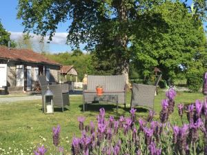 un grupo de sillas en un patio con flores púrpuras en Fonclaire Holidays Carpers Rest, en Blond