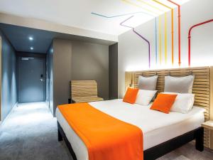 a hotel room with a bed, chair, and nightstand at ibis Styles Warszawa City in Warsaw