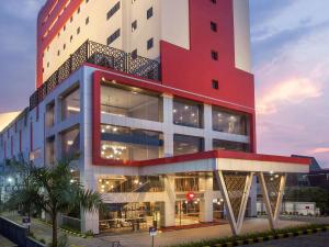 a large red and white building with a lot of windows at ibis Pontianak City Center in Pontianak