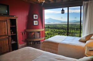 a room with two beds and a window with a view at Porton del Cielo in Pátzcuaro