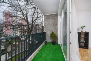 a balcony with green flooring in a building at Sunshine Parkside Hideaway - 3 Bedroom in Kraków