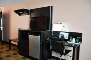 a room with a desk with a computer and a chair at Regency Inn & Suites Faribault in Faribault +21 photos