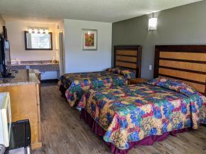 Habitación de hotel con 2 camas y lavamanos en Garden Inn & Suites, en Pensacola
