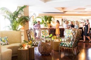 eine Gruppe von Personen in einer Lobby mit Stühlen und einer Bar in der Unterkunft The Colony Hotel in Palm Beach