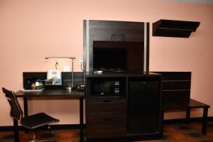 a desk with a microwave and a desk with a chair at Regency Inn & Suites Faribault in Faribault