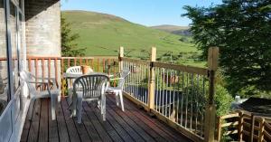 a patio with a table and chairs on a deck at Springside Chalet20 in Tywyn