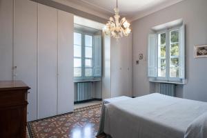 a bedroom with a bed and windows and a chandelier at Villa CORALIA D'EPOCA in Osimo +21 photos