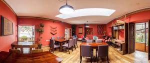 una sala da pranzo con pareti rosse e tavoli e sedie in legno di Pisac Inn a Písac