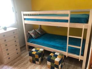 a bedroom with two bunk beds with a couch at Fresa Apartaments in La Mata +12 photos