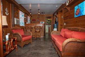 a living room with wicker furniture and a bar at Blue Island Divers Casa Descanso in Sandy Bay