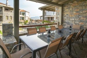 a patio with tables and chairs and a view of the ocean at Villa Ambrosia, beach house, Platanidia, Pelion in Platanidia