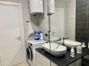 a bathroom with a washing machine and a sink at Bussola Apartment in Tirana