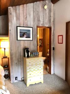 a bedroom with a wooden wall with a dresser and a picture at The Surf Lodge and Pub in Gabriola