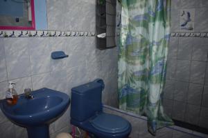 a bathroom with a blue toilet and a sink at Passion Hostel - Lima Airport in Lima