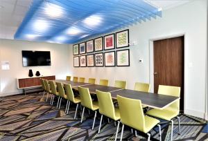 a conference room with a long table and yellow chairs at Holiday Inn Express & Suites - Forney by IHG in Forney