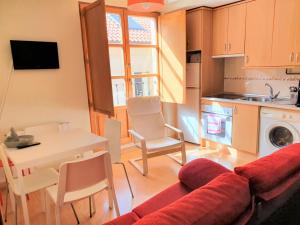 sala de estar con sofá, mesa y cocina en Duplex completo junto a la Plaza Mayor en Salamanca