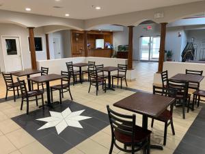 um restaurante com mesas e cadeiras num piso de azulejo em Crystal Suites em Texas City