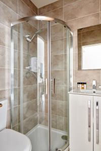 a bathroom with a shower with a toilet and a sink at Sonder St Johns Garden in London