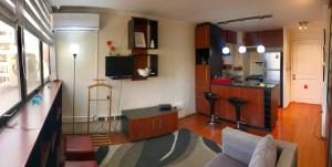 sala de estar con sofá y cocina en Estudio en el Golf, en Santiago