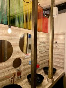 a bathroom with three sinks and two mirrors at The Corner House Hostel in Salento
