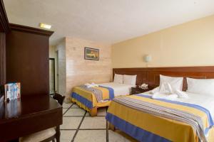 Postel nebo postele na pokoji v ubytování Hotel Ambassador Mérida