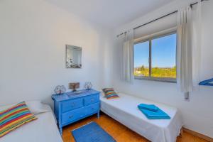 a bedroom with two beds and a window at Ceu Azul - Elevated villa with stunning views and big garden in Tavira