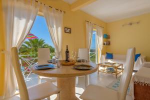 een eetkamer met een tafel en uitzicht op de oceaan bij Ceu Azul - Elevated villa with stunning views and big garden in Tavira