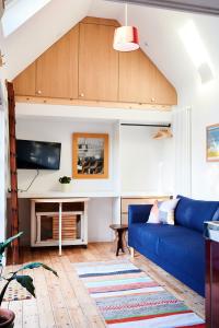 a living room with a blue couch and a tv at Tiny Cottage with Terrace & Parking, Central Lewes in Lewes