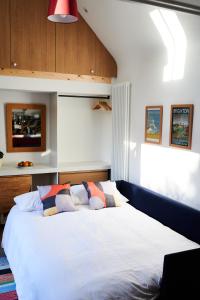 um quarto com uma cama branca com almofadas em Tiny Cottage with Terrace & Parking, Central Lewes em Lewes