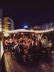 a group of people with their hands in the air at The Trip Hostel in Punta del Este