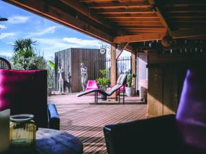 a patio with pink chairs and a table and a building at La Belle Landaise 1809 studio 4 couchages in Peyrehorade