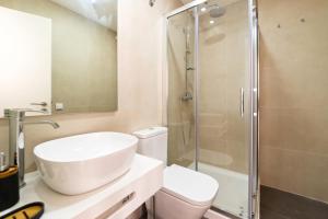 a bathroom with a toilet and a sink and a shower at The Albuquerque Suites in Lisbon