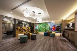 a waiting room with chairs and a wall with a painting at Stay Hotel - Taichung Zhongqing in Taichung