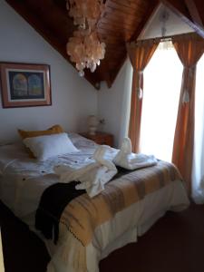 1 dormitorio con 1 cama grande y ventana en Carpe diem en San Martín de los Andes
