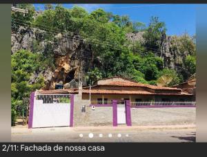 ein Gebäude mit lila Türen vor einem Berg in der Unterkunft casa pedacinho do morro in Bom Jesus da Lapa