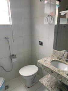 een badkamer met toilet, wastafel en douche bij Suítes Dona Paris in Capitólio +6 foto's