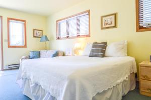 a bedroom with a large white bed and a couch at Sea Treasures Inn in Seward