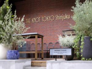 a sign in front of a brick building at THE KNOT TOKYO Shinjuku in Tokyo