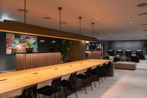 a long wooden table in a lobby with chairs at THE KNOT TOKYO Shinjuku in Tokyo