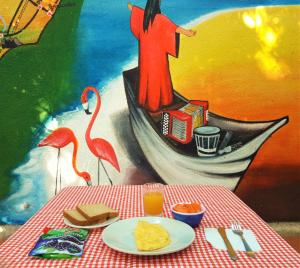 a table with a plate of food and a person on a boat at Hostal Santa Cecilia in Ríohacha