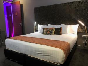 a bedroom with a large bed with a large headboard at Junction Hotel in Newcastle